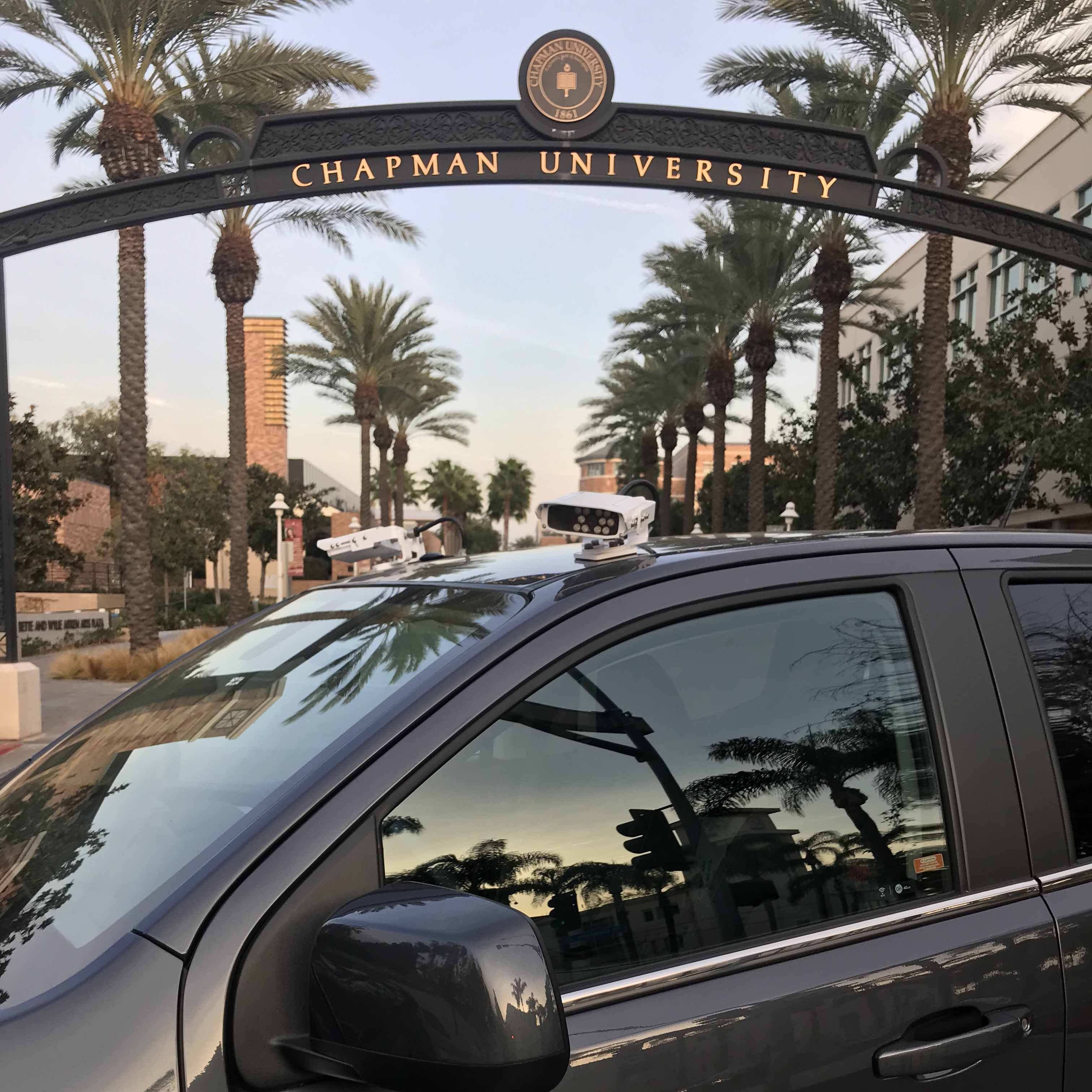 Chapman parking enforcement vehicle in front of university sign
